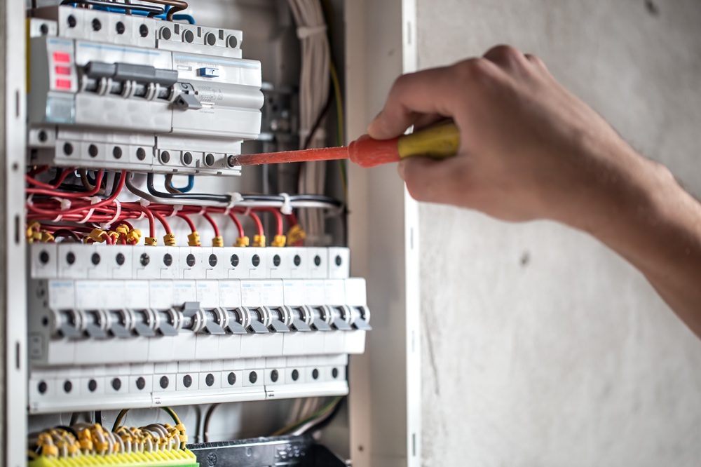 man electrical technician working switchboard with fuses installation connection electrical equipment close up 1.jpg
